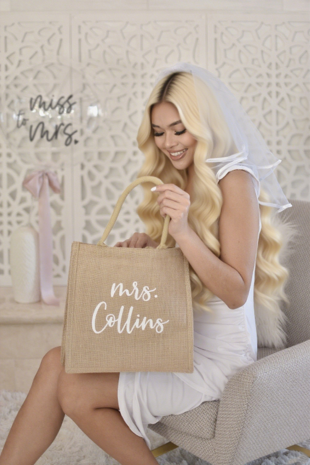 Woman in a white dress holding a 'Mrs. Collins' burlap tote bag