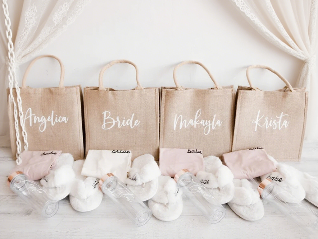 A personalized name burlap tote bag with bridesmaid gifts next to it