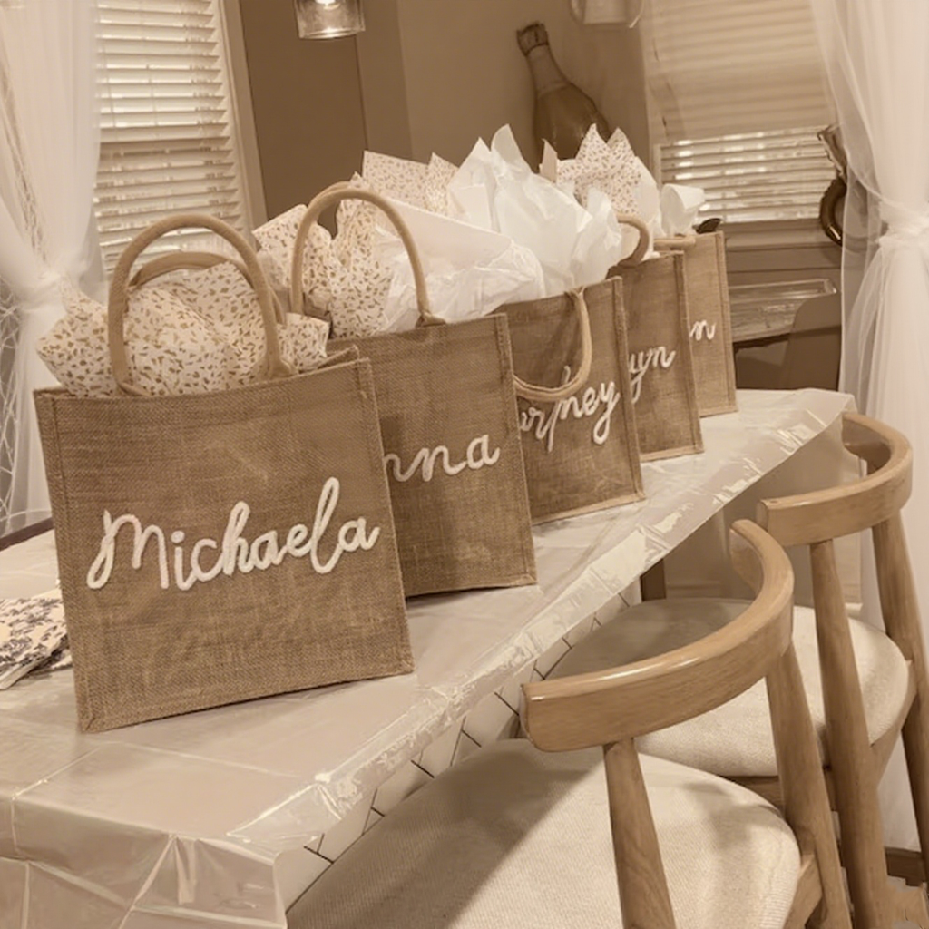 Burlap bags with personalized names on a table in a room.